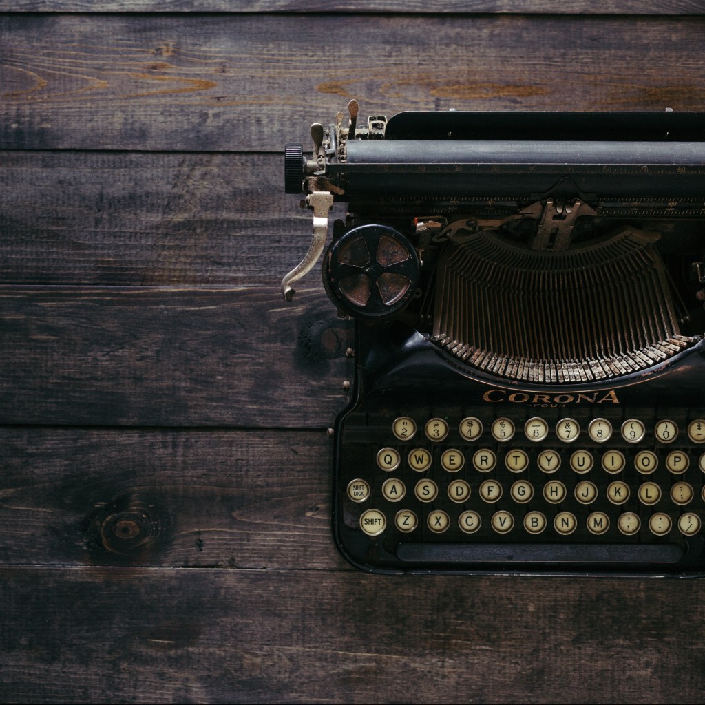 antique type-writer sitting on dark wood